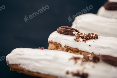 Preview: Close-up of eclairs in white glaze with pecans.
