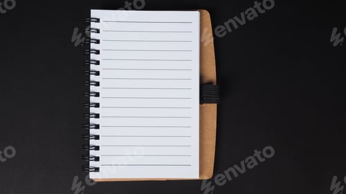 Preview: Paper note or notebook isolated on black background.