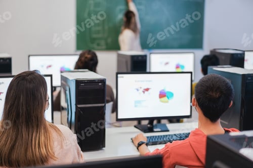 Preview: Multiracial students using computers during business class wearing safety masks at school