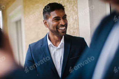 Preview: Handsome man smiling wearing a suit in a conversation