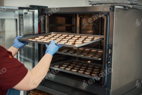 Preview: Unrecognised cook baking a batch of macarons in the oven