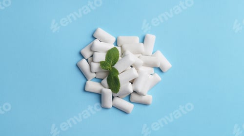 Preview: Tasty chewing gums and mint leaves on light blue background, flat lay