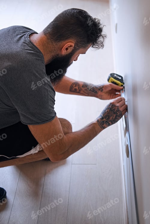 Preview: Carpenter measuring a wall.