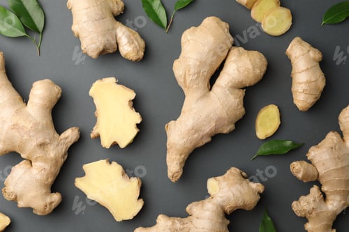 Preview: Fresh ginger with green leaves on dark background, flat lay