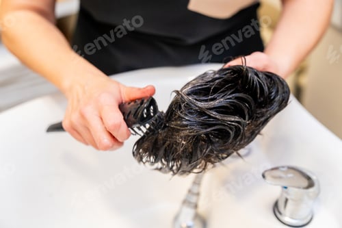 Preview: Stylist Brushing Dark Hair in a White Sink