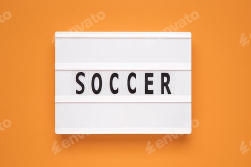 Preview: The word soccer on lightbox isolated orange background.