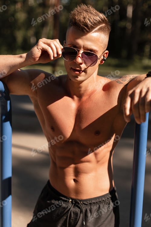 Preview: Cool handsome healthy muscular athletic man training outdoors