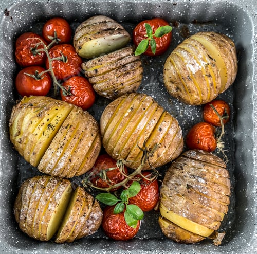 Preview: Baked potatoes in baking form with vegetables top view.