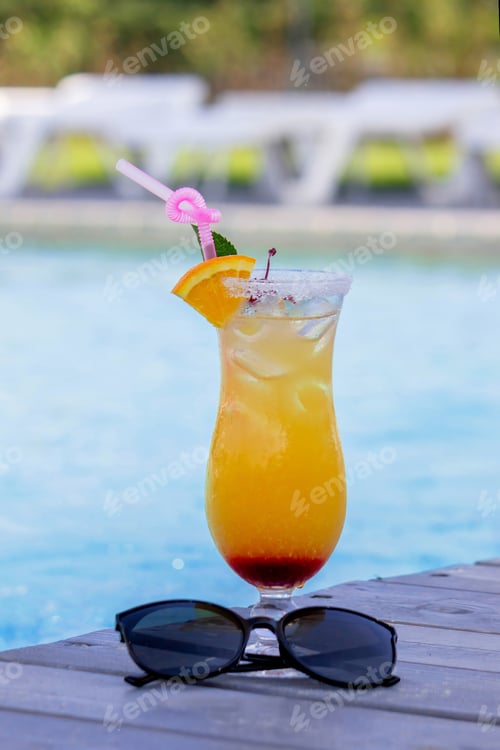 Preview: A nice cocktail, hat and sunglasses by the pool