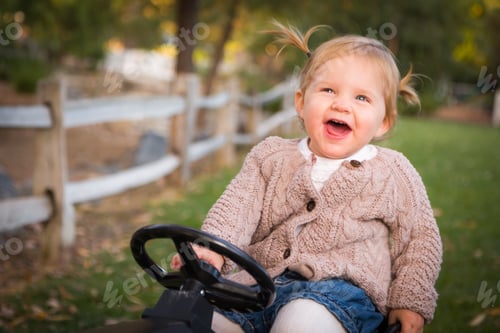 Preview: Young Toddler Laughing and Playing on Toy Tractor Outside