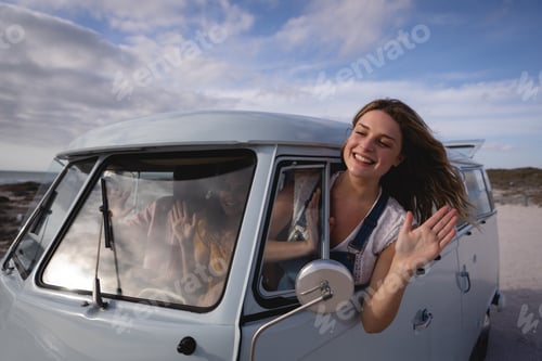 Preview: oman having his head outside the camper van while she is waving out by window
