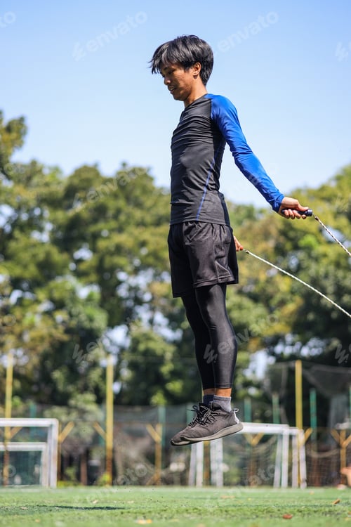 Preview: Fit young man working out with skipping jump rope on workout outdoor.