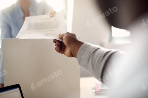 Preview: Close-up of coworkers working on business reports in the office.