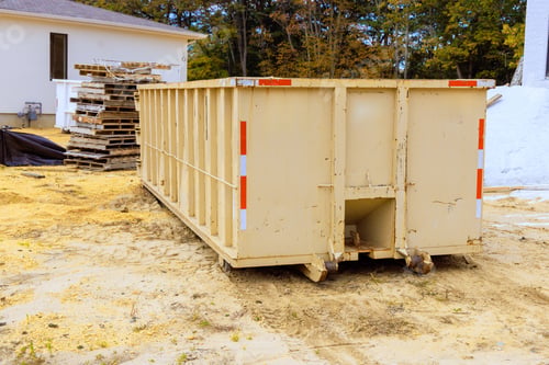 Preview: Large waste container located on construction site during works day with wooden pallets nearby