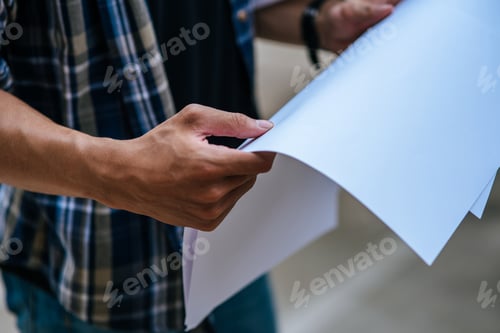 Preview: Architects hold the building plan and check the work.