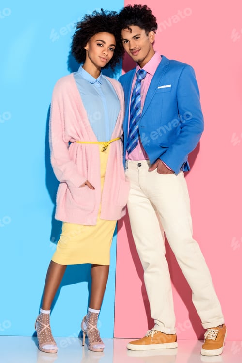 Preview: Young african amercian smiling girl and guy hugging on pink and blue background