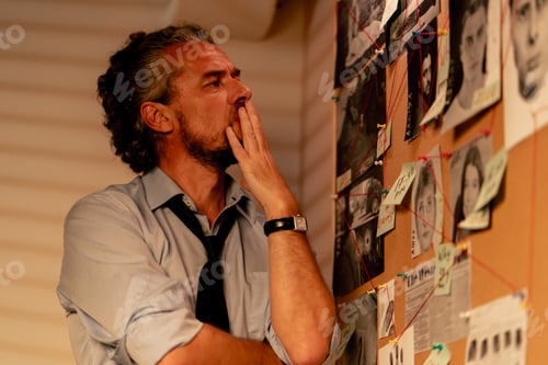 Preview: close up detective office middle aged investigator in shirt and tie standing near clue board for