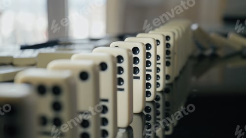 Preview: Falling domino pieces trigger a continuous chain reaction. Symbol of cause and effect