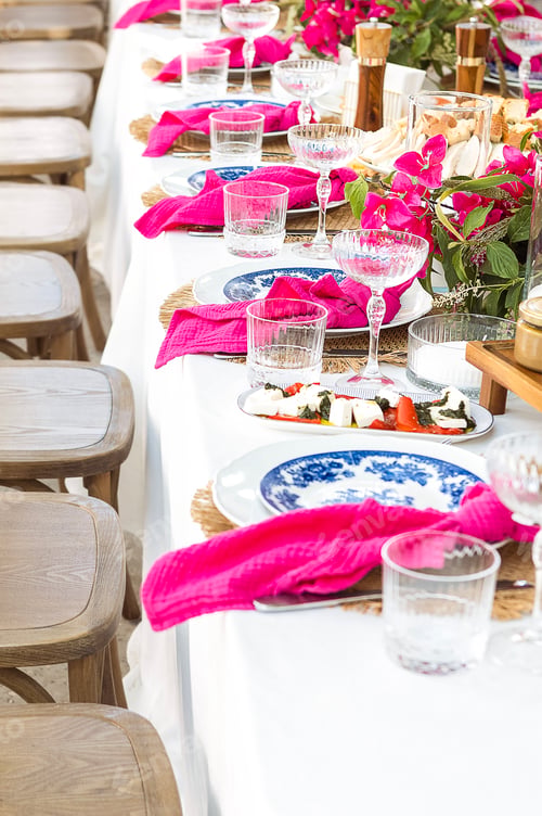 Preview: A set festive table in the open air. The table is decorated with candles and flowers