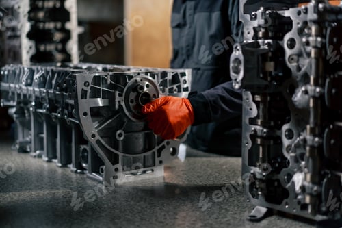 Preview: service station on the table young engine repairman manually cranks the crankshaft in the engine