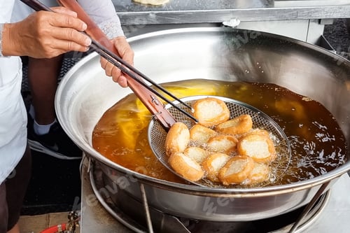 Preview: Hawker scooping out cooked Ham Chim Peng from wok, a popular Chinese street food in Malaysia