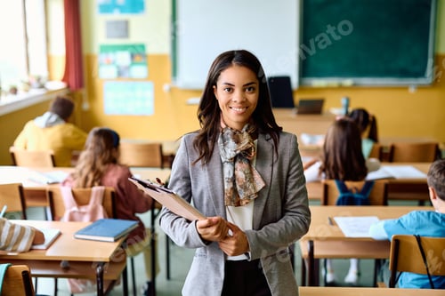 Preview: Portrait of happy Hispanic teacher during a class at elementary school looking at camera.
