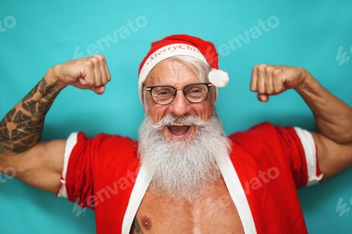Preview: Happy fit senior man having fun wearing Santa Claus clothes and celebrating Christmas holidays