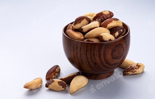 Preview: Brazil nuts in wooden bowl on white background