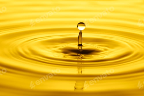 Preview: Yellow drop falling creating a splash of oil or water background. Olive, sunflower, cosmetic oil