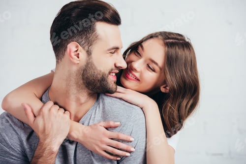 Preview: selective focus of happy couple embracing and smiling in bedroom