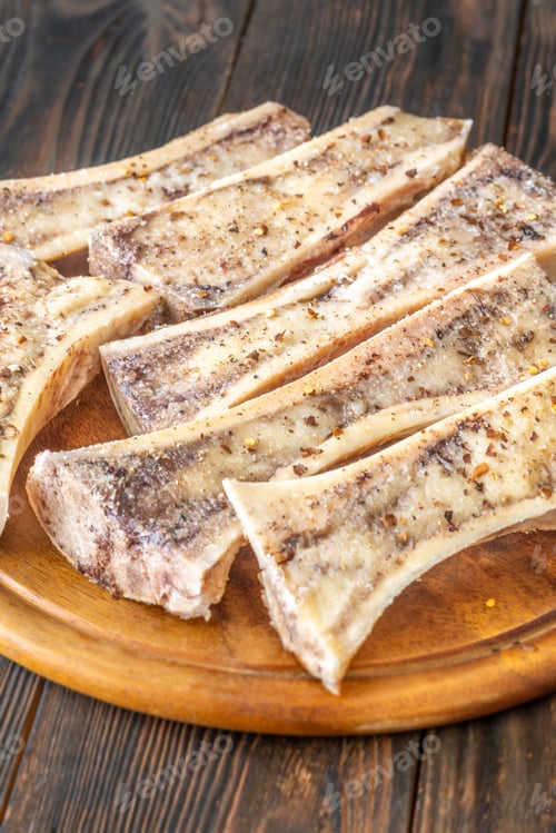 Preview: Rustic roasted marrow bones rest on warm wooden board, savory richness revealed
