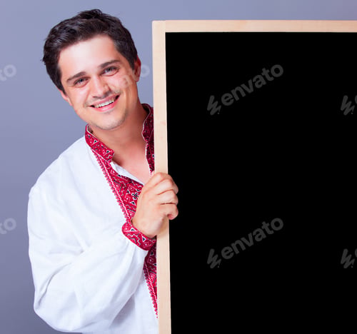 Preview: Handsome man in national embroidery with blackboard.