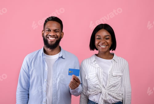 Preview: Portrait of happy black millennial couple promoting bank services, showing credit card on pink
