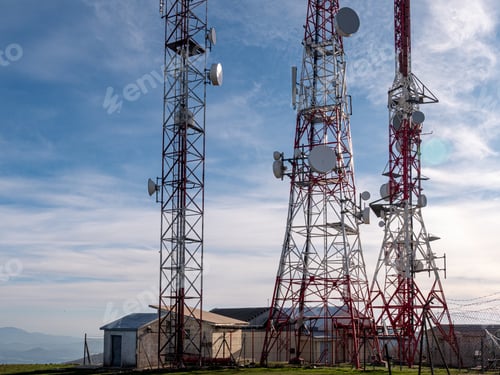Preview: Cloudy sky behind telecommunication wireless towers with antennas