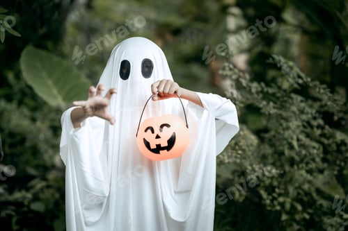 Preview: A young boy dressed as a ghost for Halloween wears a white sheet with black eye holes