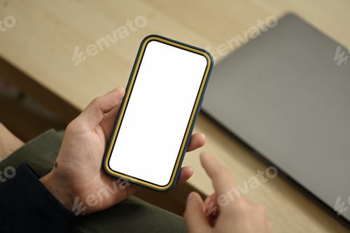 Preview: Unrecognizable young man hands holding mobile phone with empty screen sitting on couch