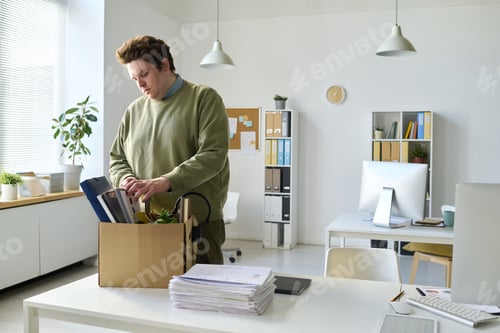 Preview: Office worker packing his things in box after layoff