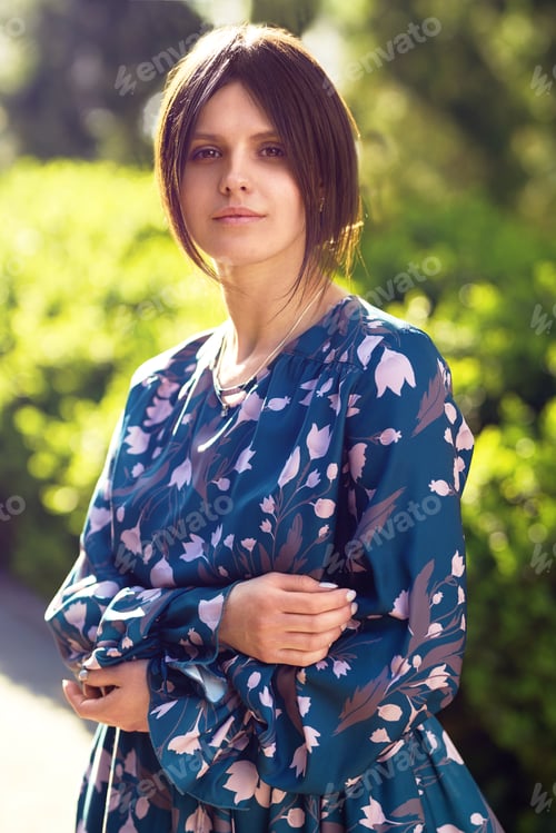 Preview: Beautiful young woman near the blooming spring tree. Attractive girl enjoying her time in park.