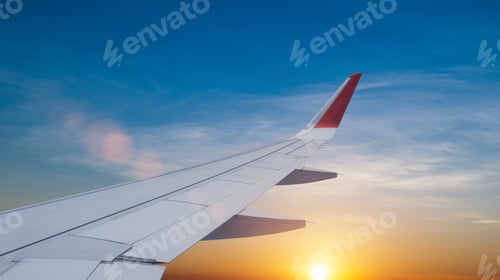 Preview: Airplane flying low over foggy mountains, view from plane window of plane wing and sky sunrise