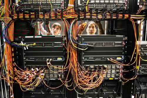 Preview: technicians working on a CAT 5 cable bundling system in a server room