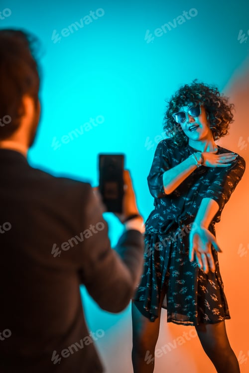 Preview: Party lifestyle, a very happy couple dancing at a party with blue and orange lights