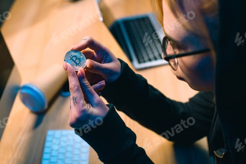 Preview: close-up shot of young female hacker holding bitcoin