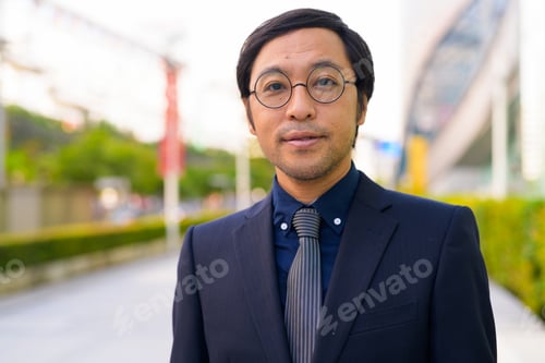 Preview: Face of Asian businessman with nature in the city outdoors