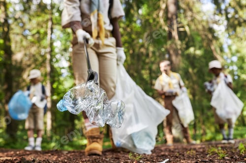 Preview: Closeup of scouts picking up trash in forest
