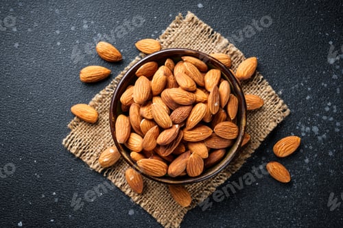 Preview: Almond nuts in bowl at black background.