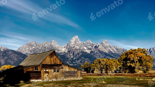 Preview: Rustic wooden barn in the foreground of a majestic mountain range