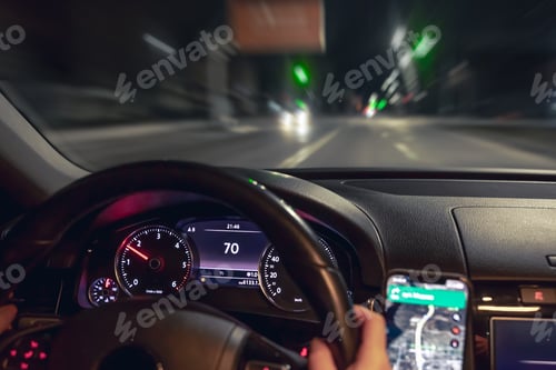 Preview: Car steering wheel and view of the night road from the car, close-up.