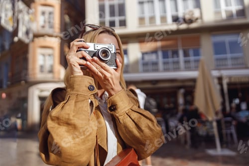 Preview: Portrait of smiling woman holding retro camera looking at viewing slot
