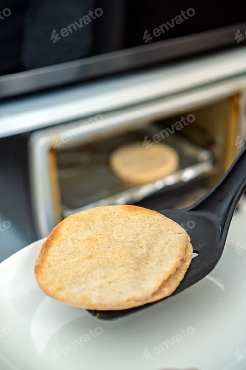 Vista previa: Retirar el pan plano recién horneado del horno para el desayuno