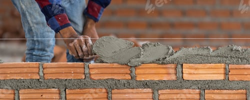 Preview: Banner of Closeup hand professional construction worker laying bricks in new industrial site